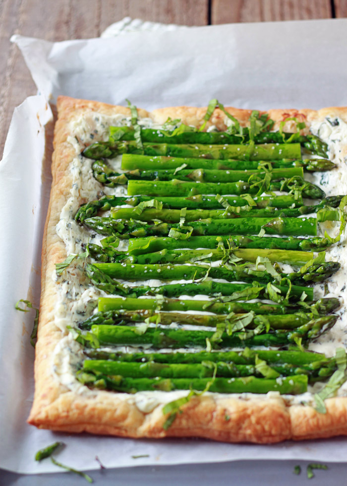 Asparagus Cream Cheese Tart recipe - Tender asparagus and tangy basil cream cheese top golden puff pastry in this easy vegetarian tart. Got carnivores too? Just top individual squares with crumbled bacon for the meat-eaters.
