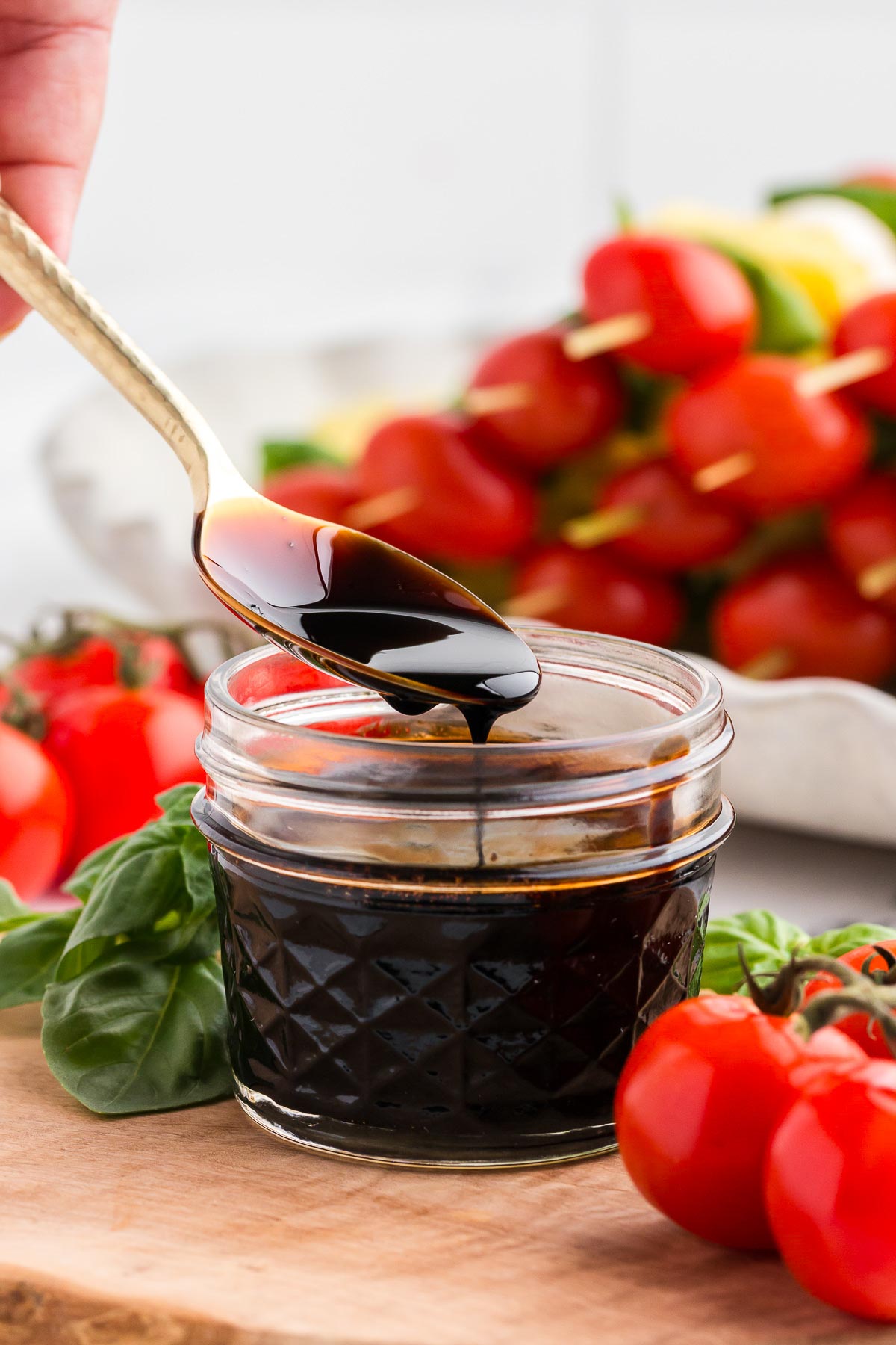 a spoon scooping balsamic glaze out of a jar