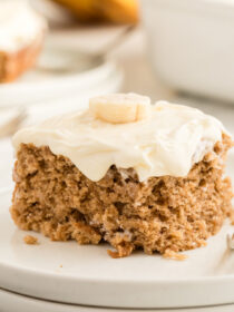 A piece of banana spice cake on a white plate.