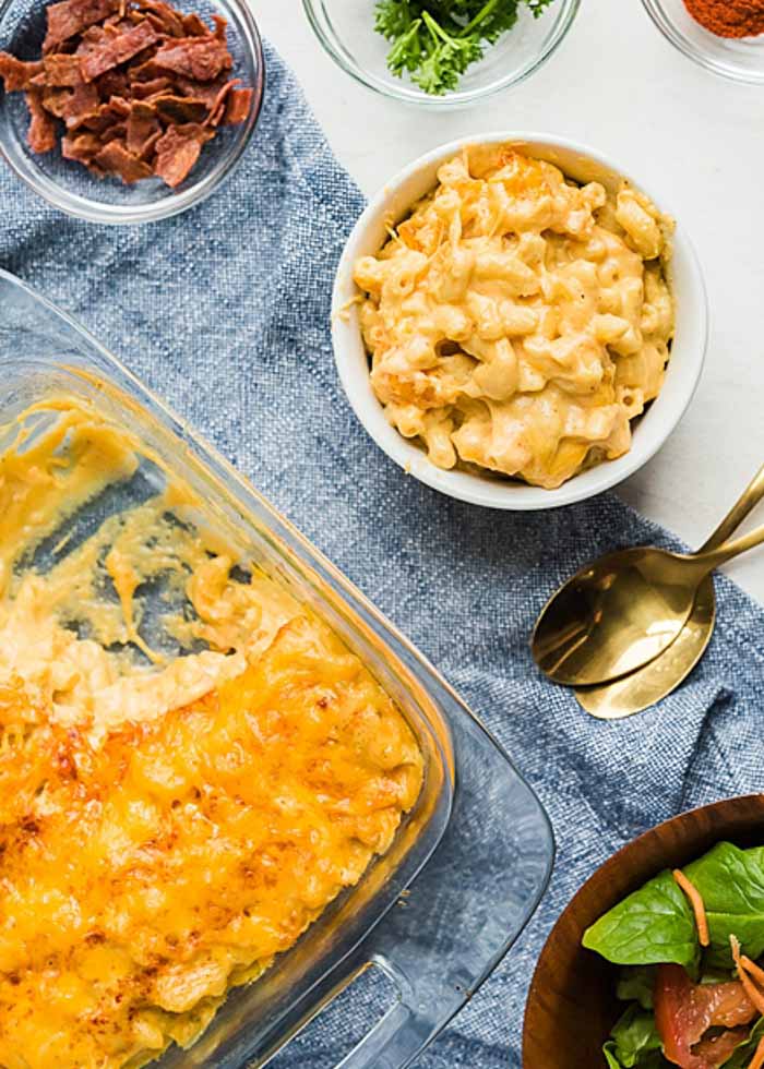 A serving of the best baked macaroni and cheese with a green salad and bacon as an optional topping