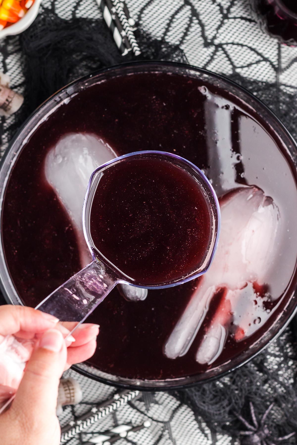 ladling Black Magic Halloween Punch out of a punch bowl