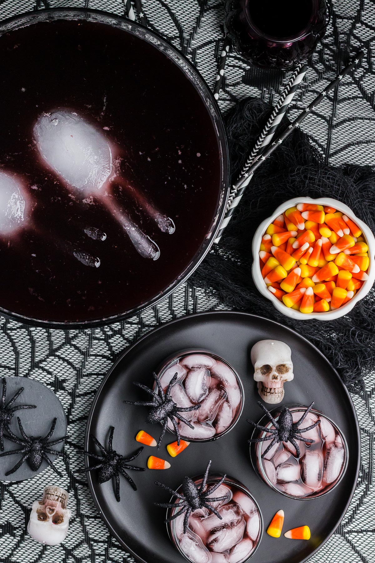 Black Magic Halloween Punch in a punch bowl and a tray with individual glasses full of the punch