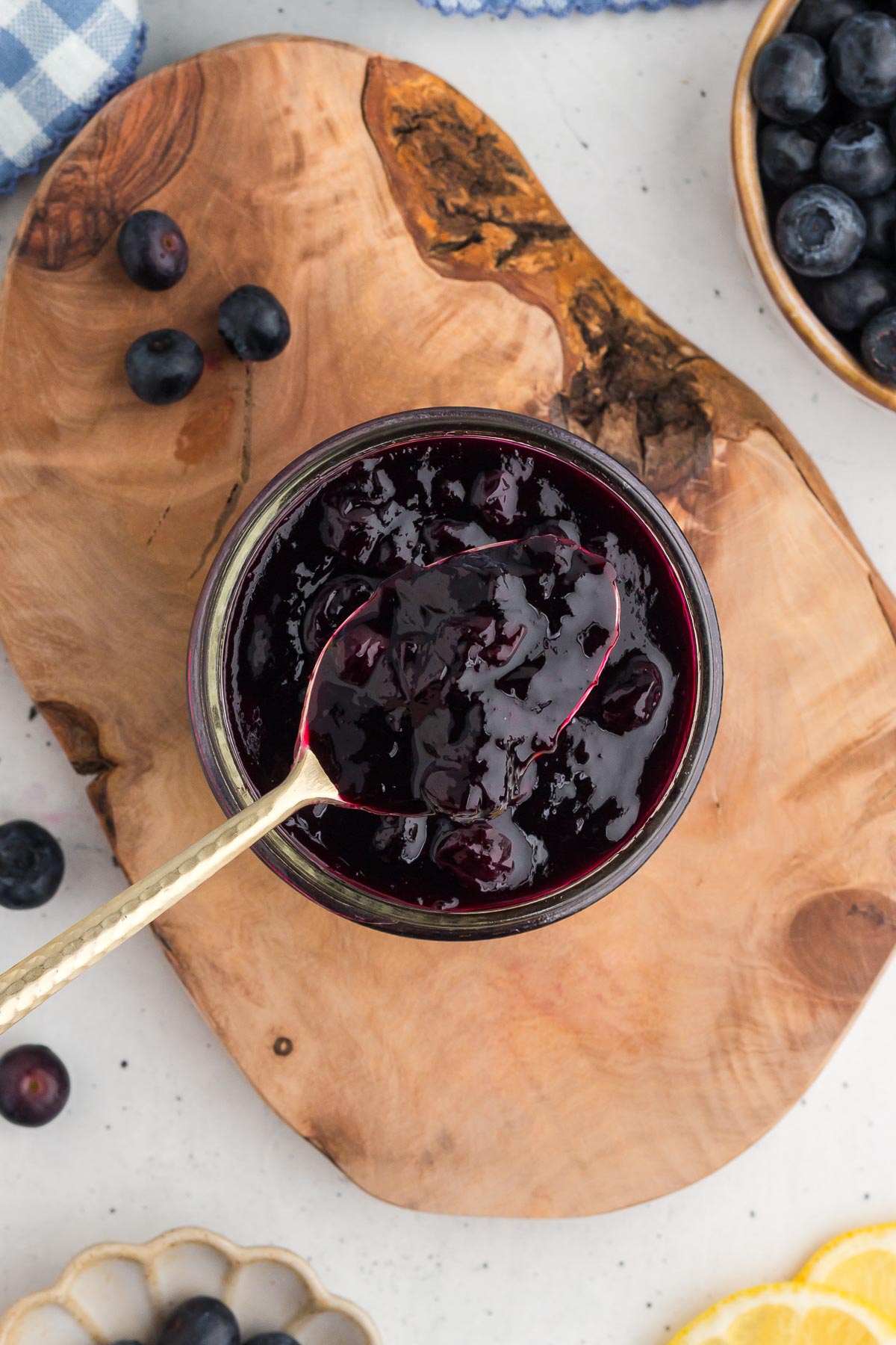 Top view of a spoon in a jar of blueberry sauce