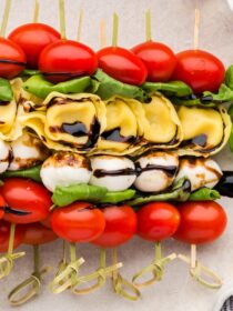 Caprese Tortellini Skewers on a platter with basil garnish