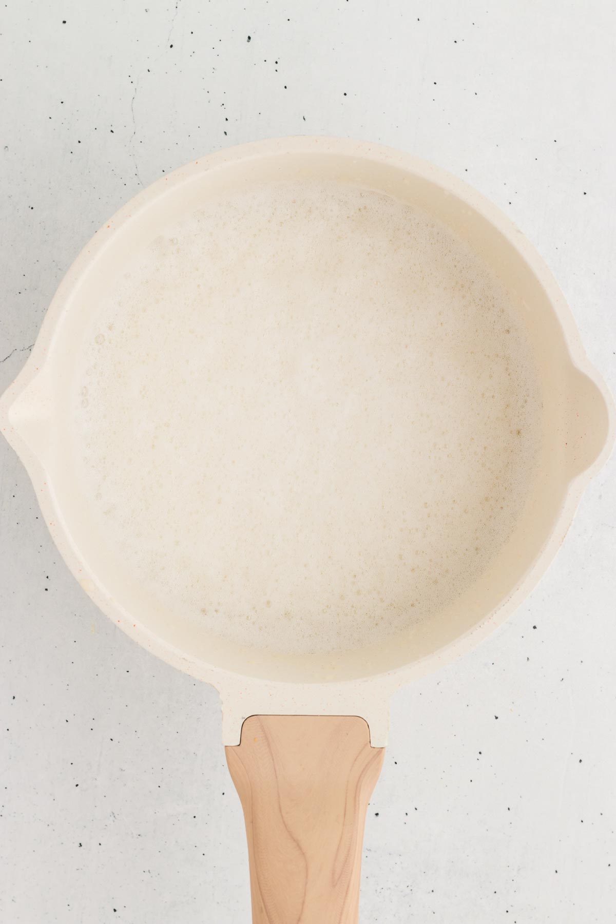 Top view of a saucepan full of frothed oat milk for chamomile latte