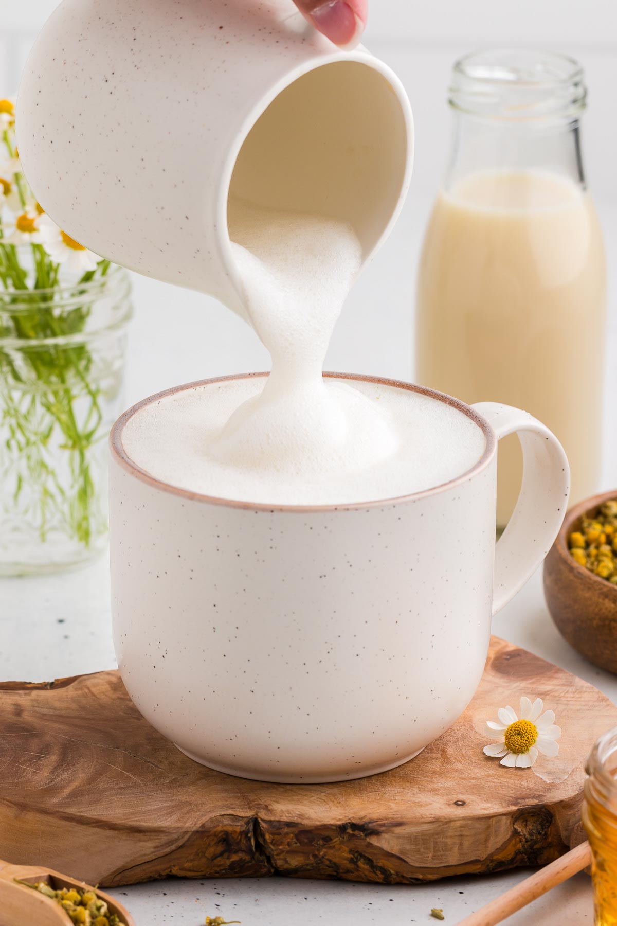 Adding frothed milk to a chamomile latte