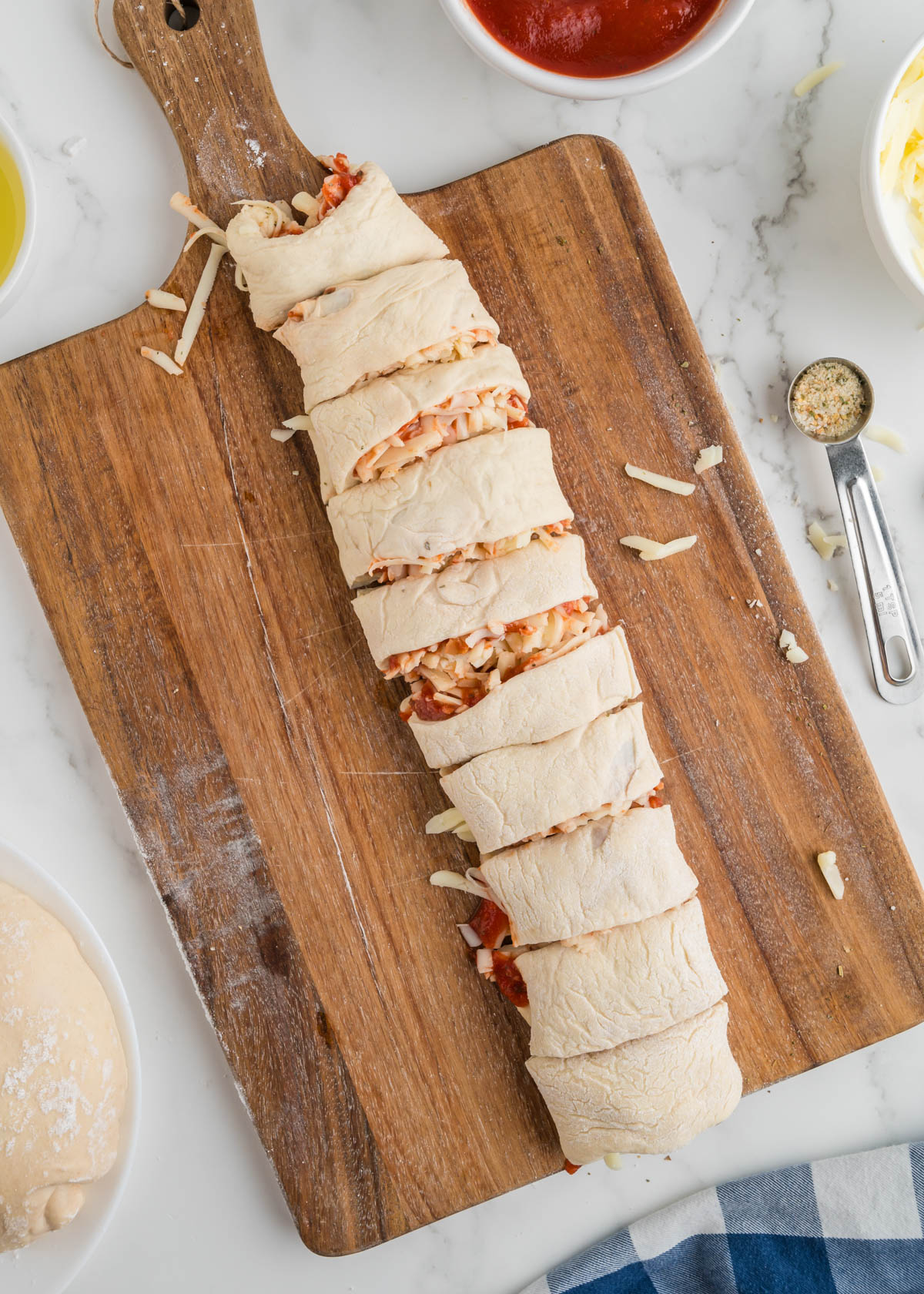 A roll of pizza is cut into slices for pizza pinwheel appetizers