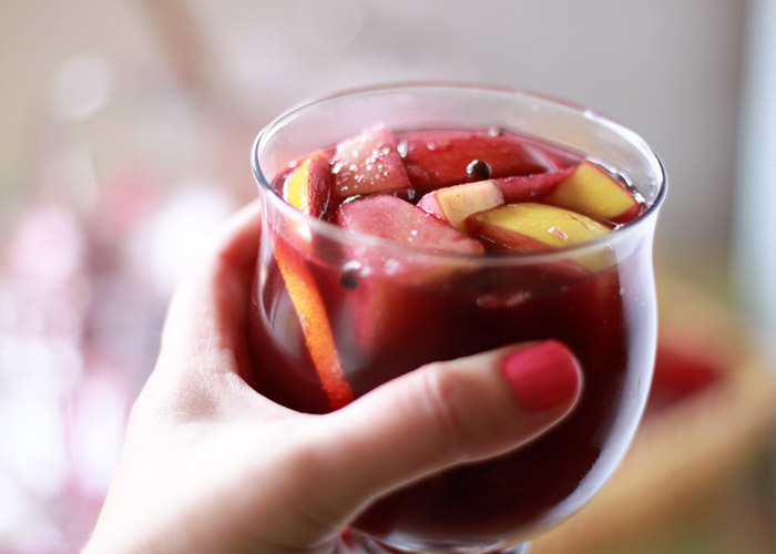 A hand holding a glass of classic traditional red wine sangria. 