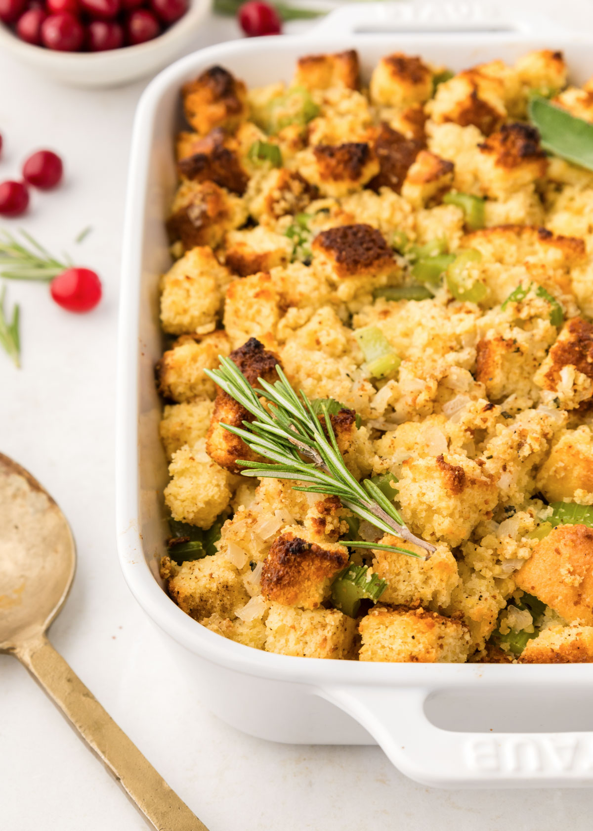 A close-up of Cornbread Stuffing in a white casserole dish.