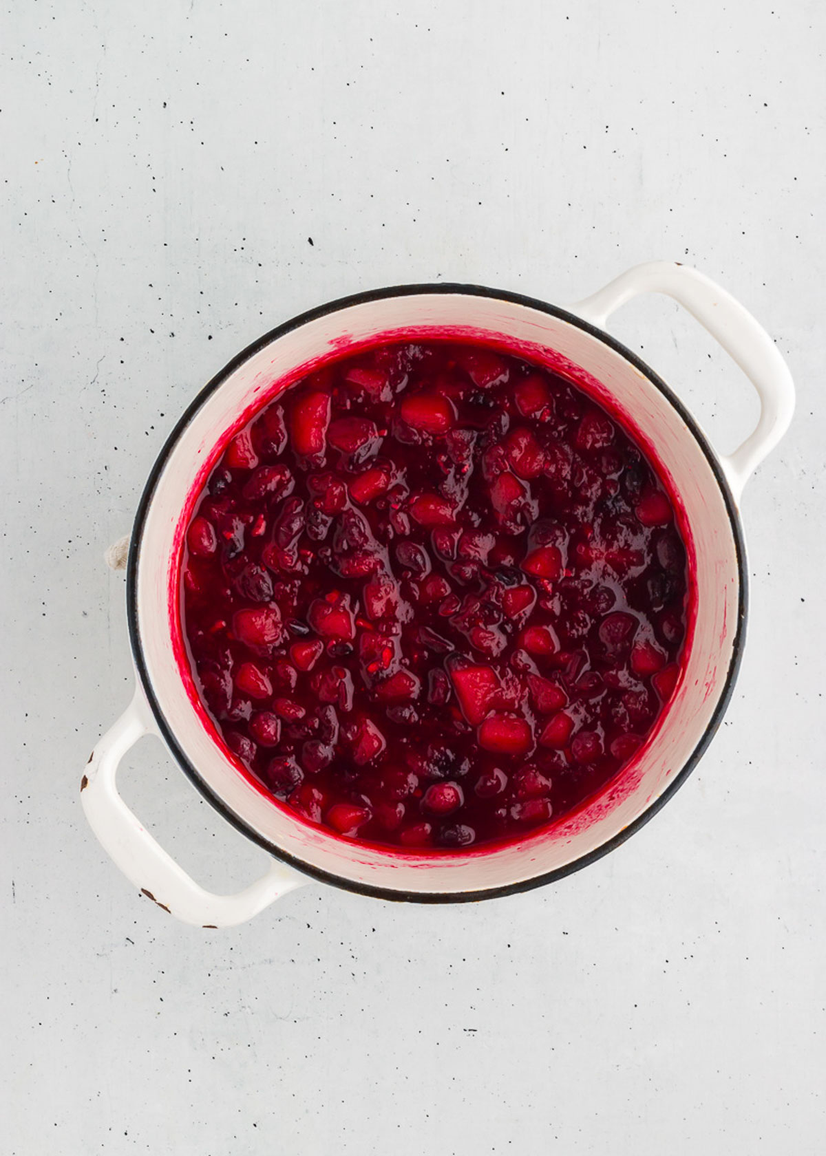 ginger pear cranberry sauce being cooked in a saucepan
