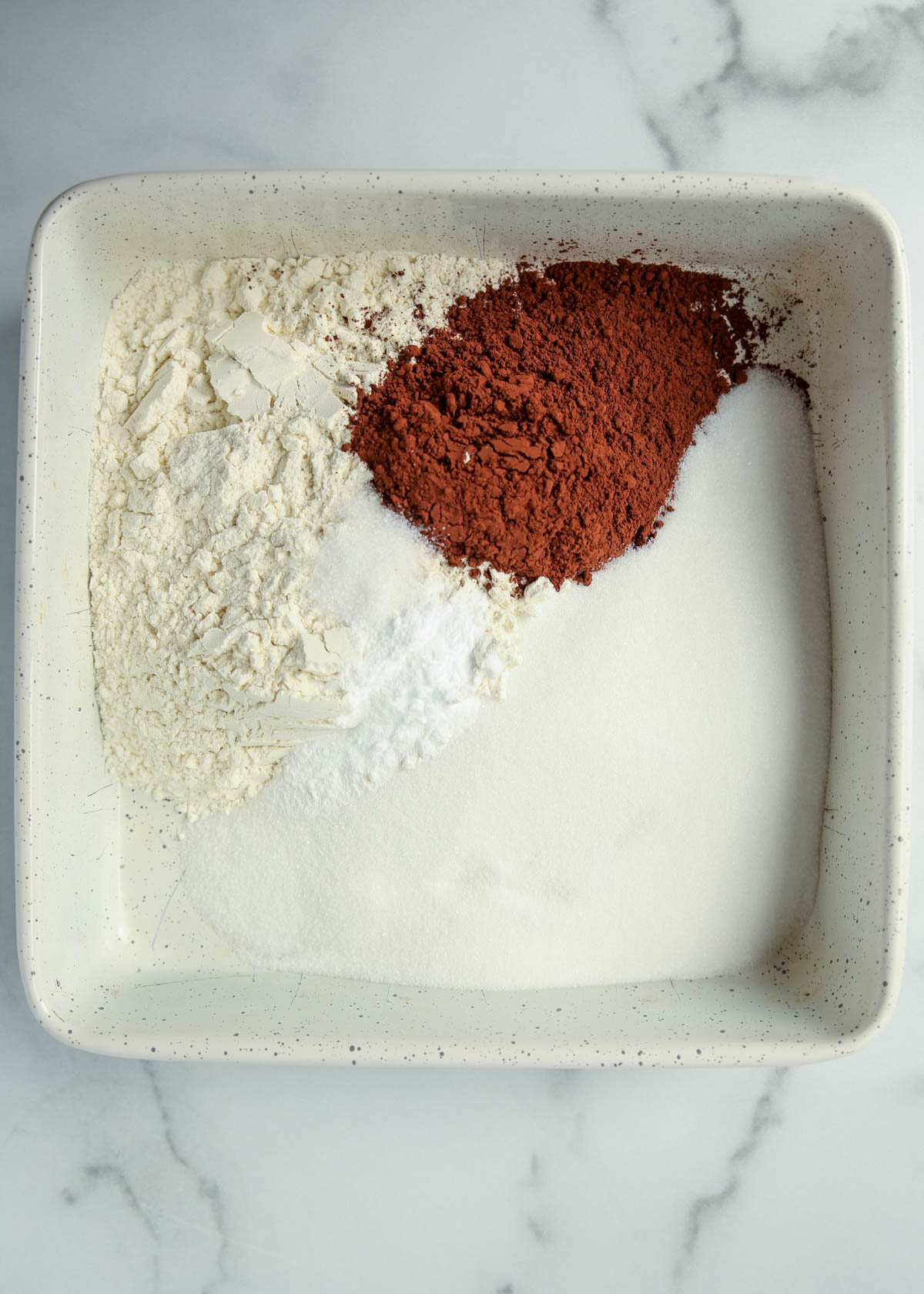 Dry ingredients for chocolate wacky cake in the baking pan.
