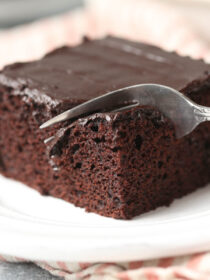 A fork cuts into a square of chocolate wacky cake