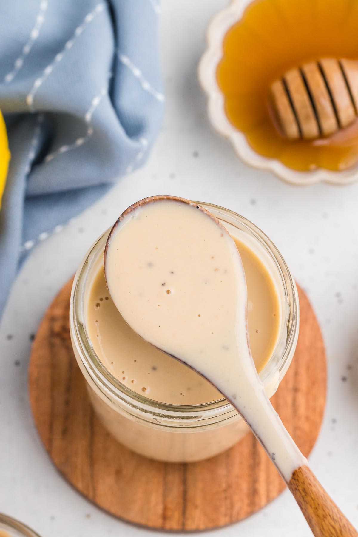Top view of Creamy Lemon Tahini Dressing in a mason jar with a spoon full of dressing.