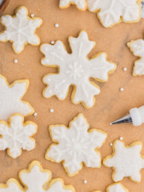 Snowflake sugar cookies on parchment paper.