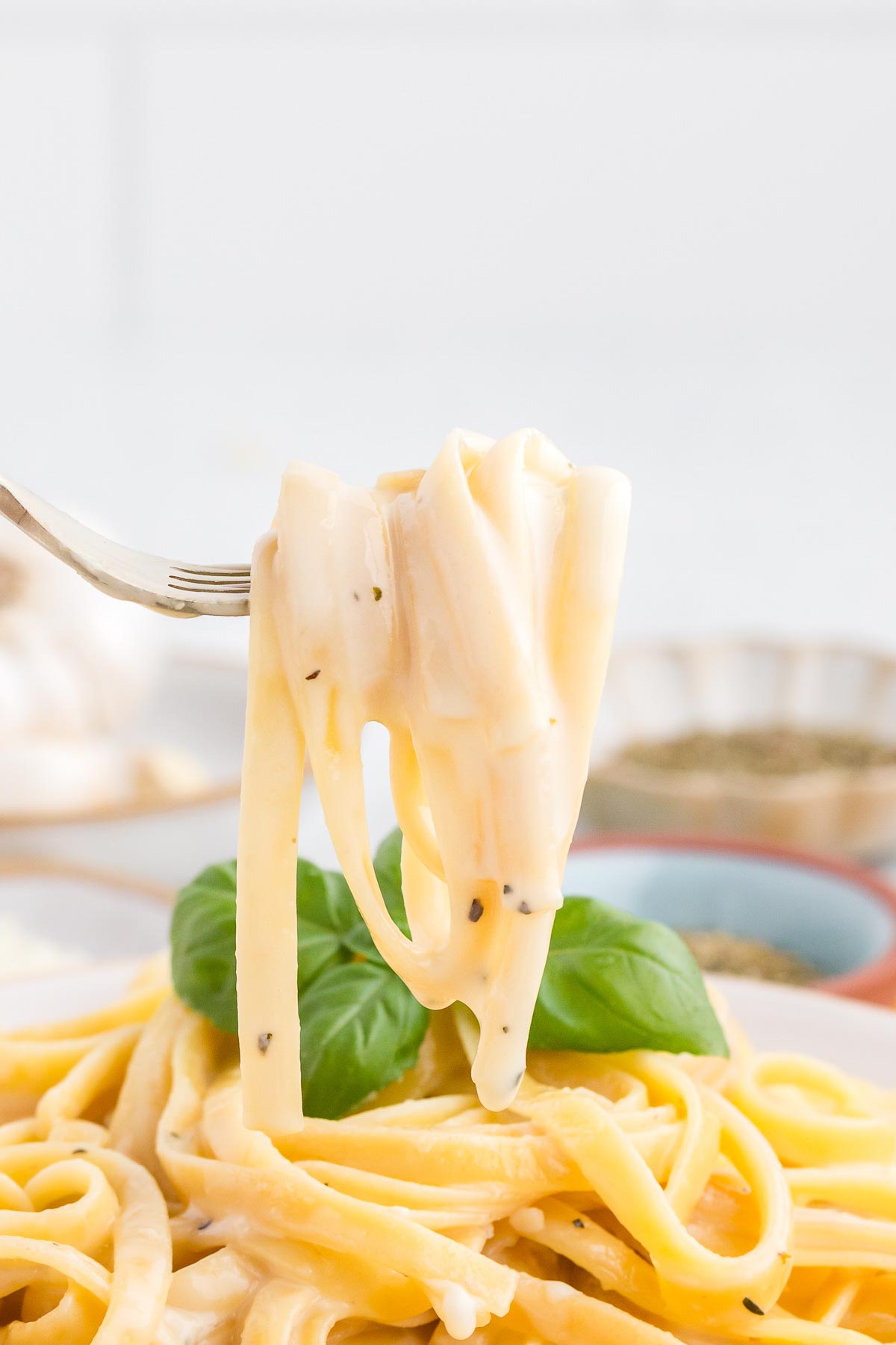 a fork scooping up pasta with homemade alfredo sauce