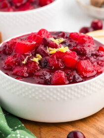 ginger pear cranberry sauce in a white bowl with lemon zest garnish.