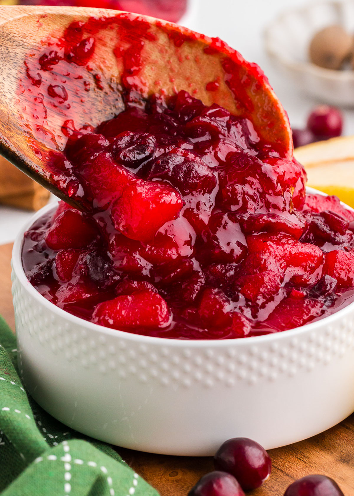 Cranberry sauce being spooned into a white bowl