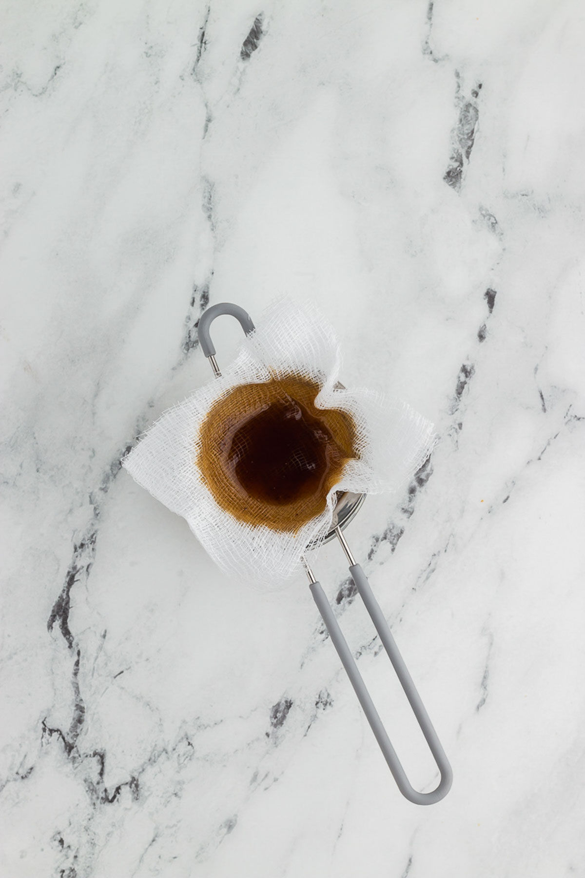 Straining homemade gingerbread coffee syrup