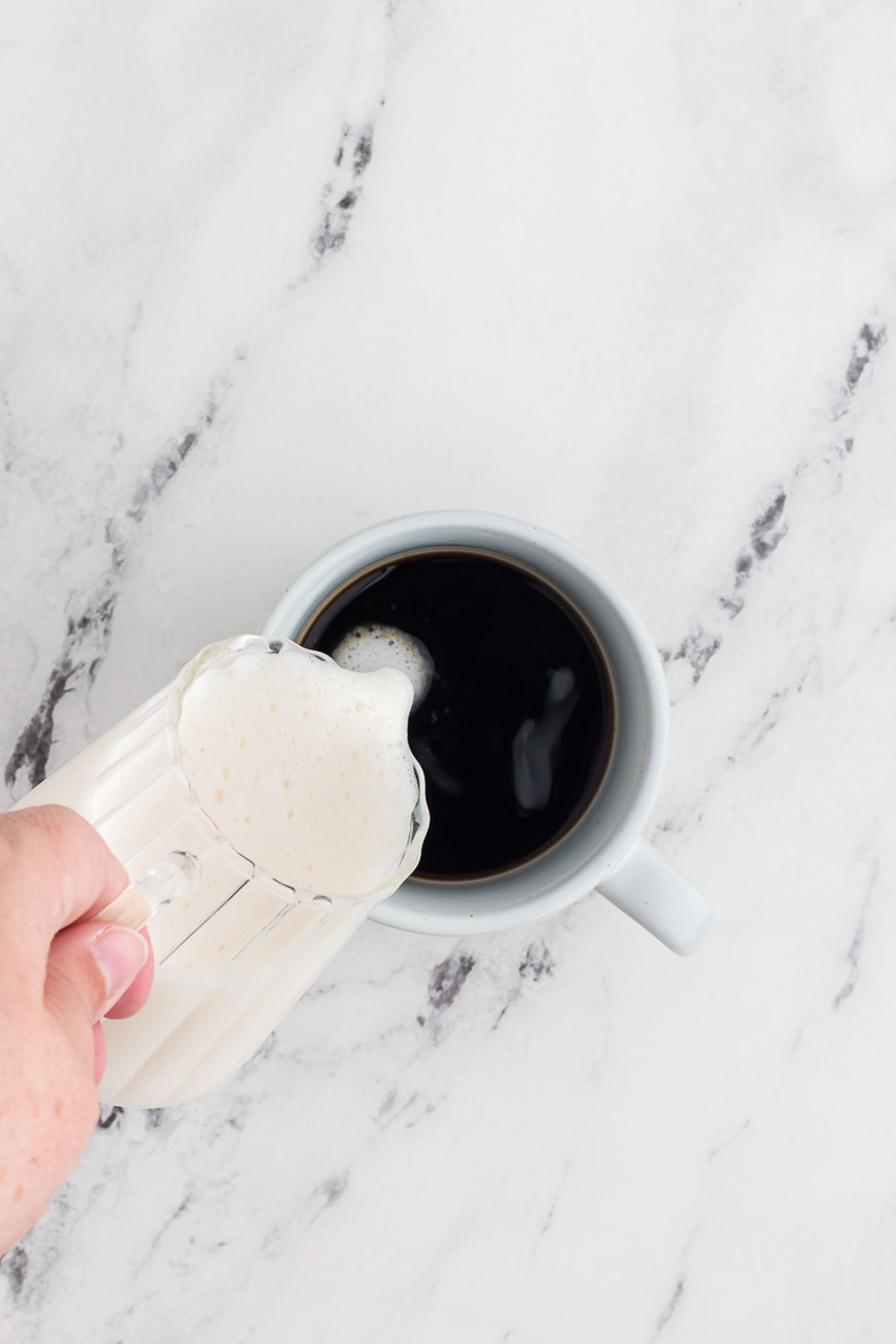 pouring frothed milk into coffee for a gingerbread latte