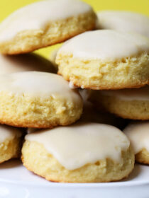 A pile of almond flour lemon cookies on a white platter.