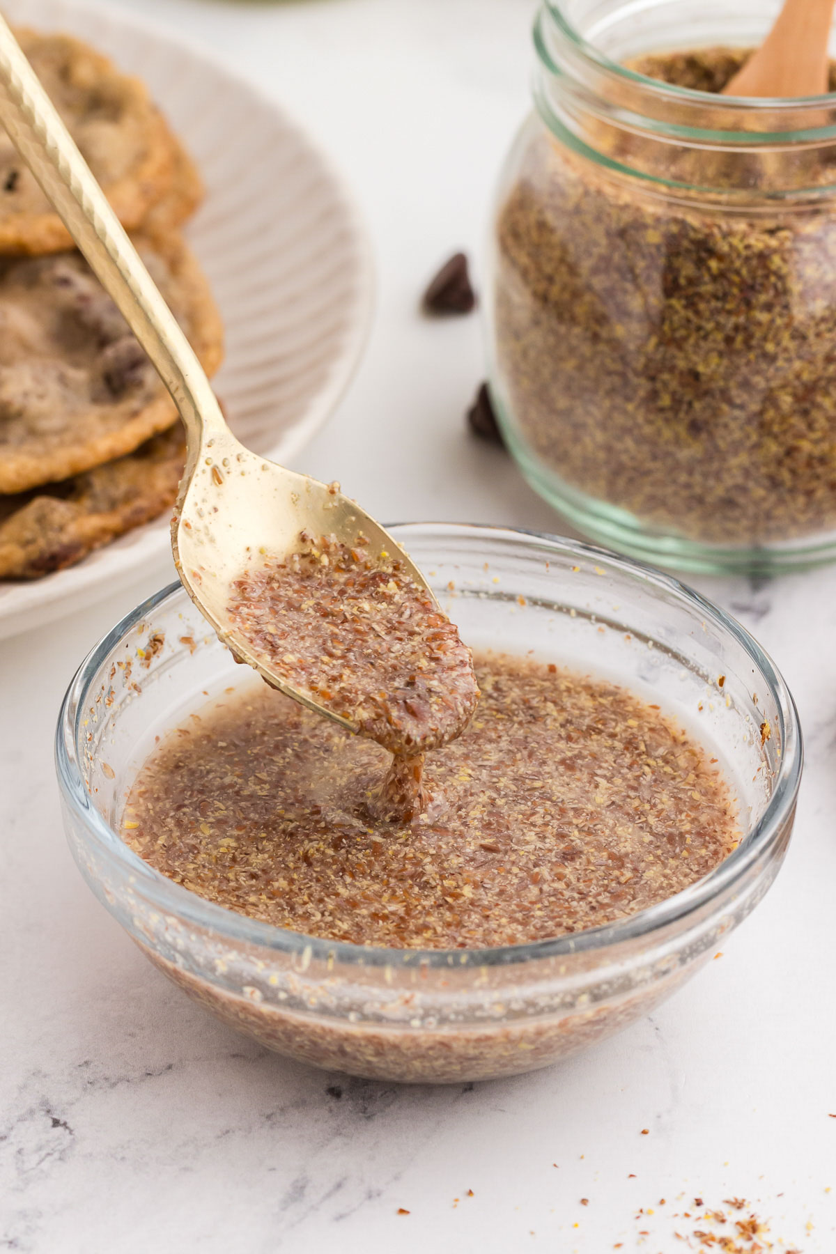 A gold spoon full of flax egg spilling out, showing how thick flax eggs are.
