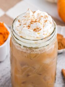 Iced Pumpkin Spiced Latte with whipped cream in a mason jar