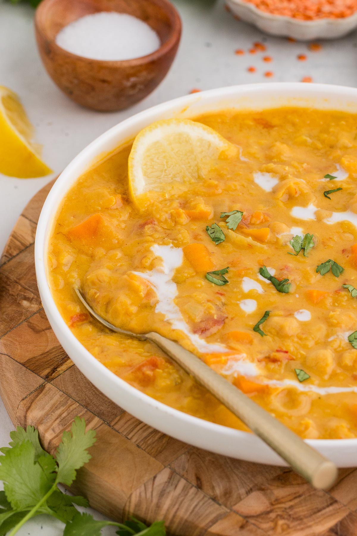 Instant Pot Coconut Red Lentil Soup with Chickpeas in a white bowl with a silver spoon.