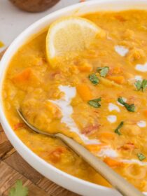 Instant Pot Coconut Red Lentil Soup with Chickpeas in a white bowl with a silver spoon.