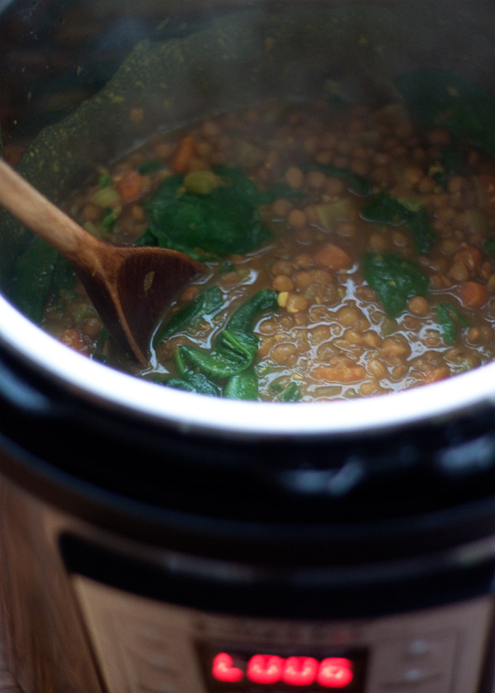 Stirring the spinach into Instant Pot while making Golden Lentil and Spinach Soup