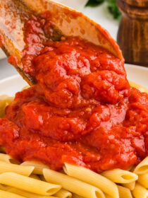 3-ingredient pasta sauce being spooned onto penne pasta