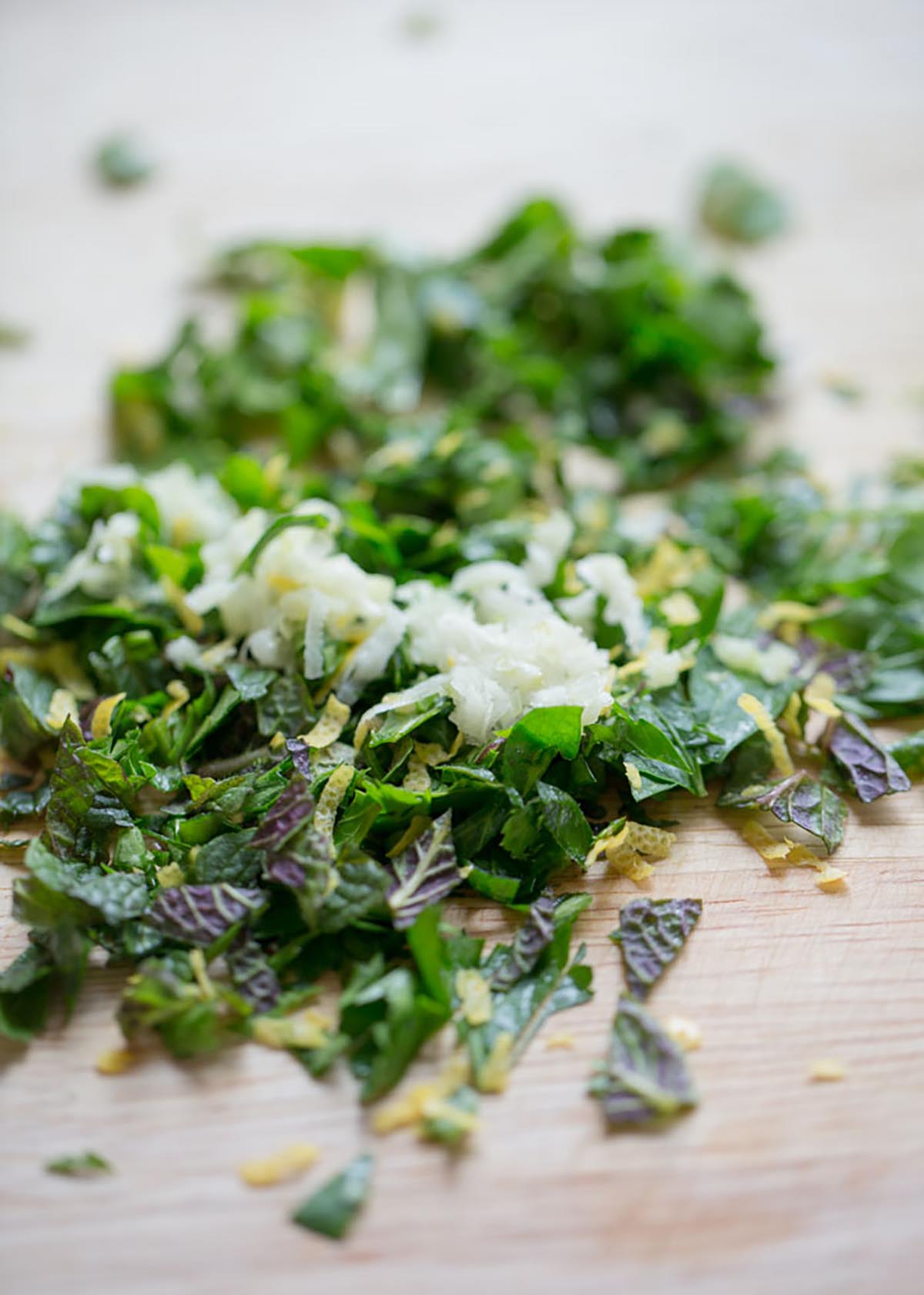 Grated garlic, lemon zest, parsley, and mint are diced together to make gremolata. 