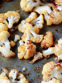 Maple-Sriracha Roasted Cauliflower recipe - Cauliflower, tossed in maple syrup and spicy Sriracha, gets crispy-edged and caramelized in the oven. This irresistibly sweet/spicy cauliflower is equally perfect for game-day snacking, a dinner side, or just straight-up lunch.