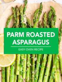 A top view of a white plate lined with parchment paper and parmesan roasted asparagus on top with lemon as garnish. The text, on a green background, reads, "parmesan roasted asparagus."