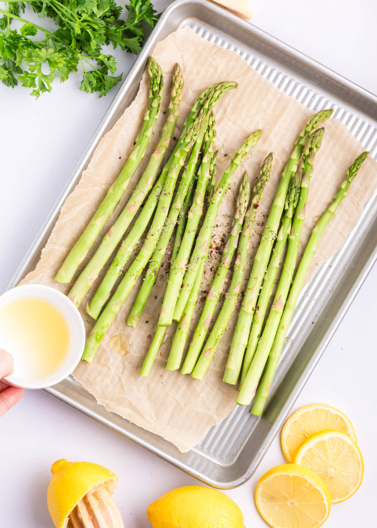 Parmesan roasted asparagus being prepared for the oven.