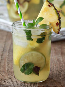 a mason jar full of pineapple mojito sangria with pineapple garnish