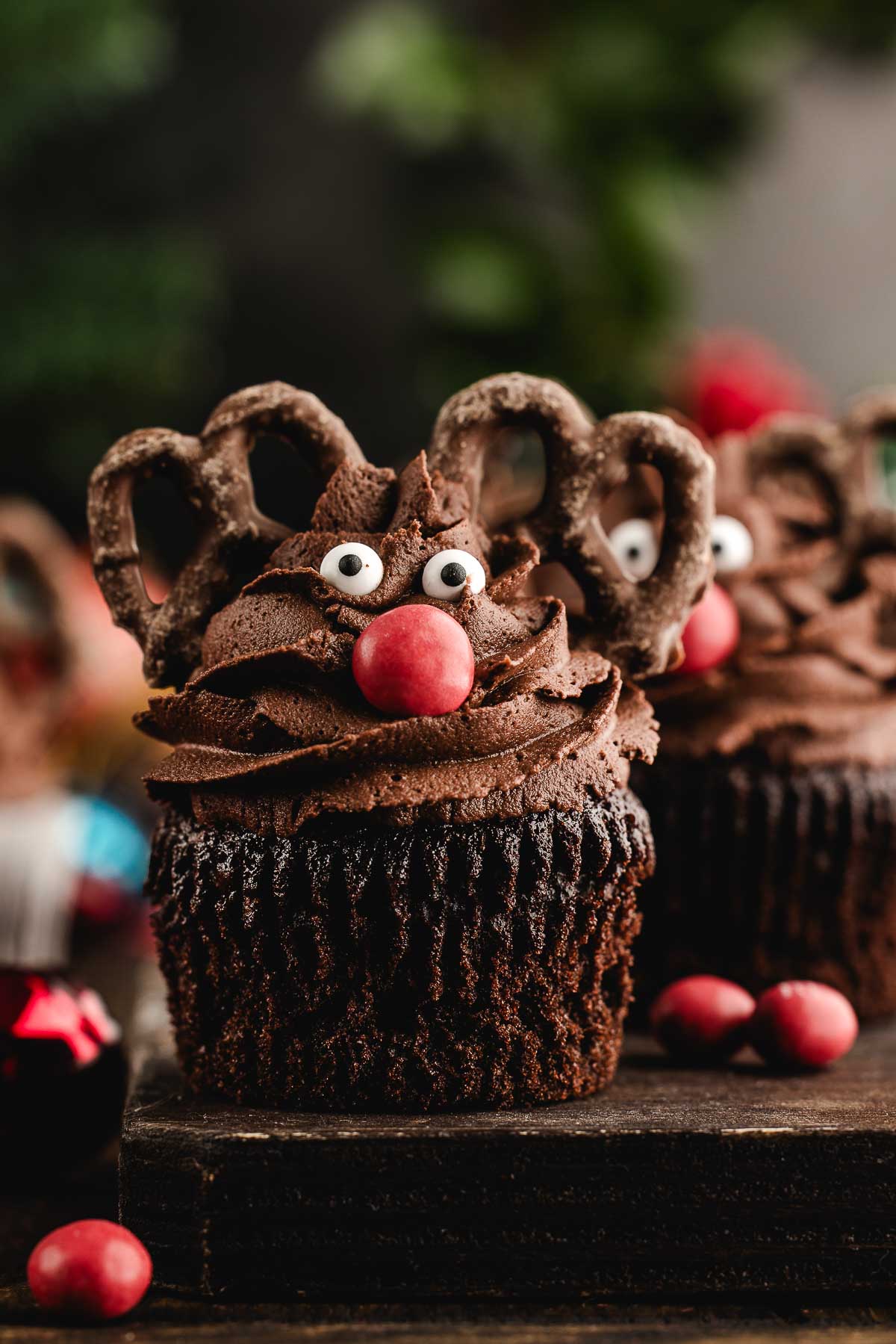 reindeer cupcake on a wooden board with red M&Ms in the background