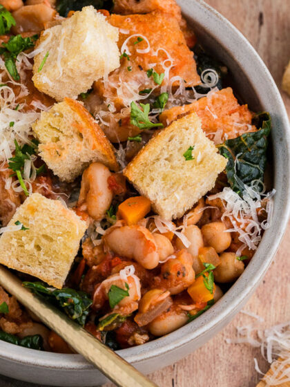 A top view of a bowl of ribollita Toscana in a white bowl with a gold spoon