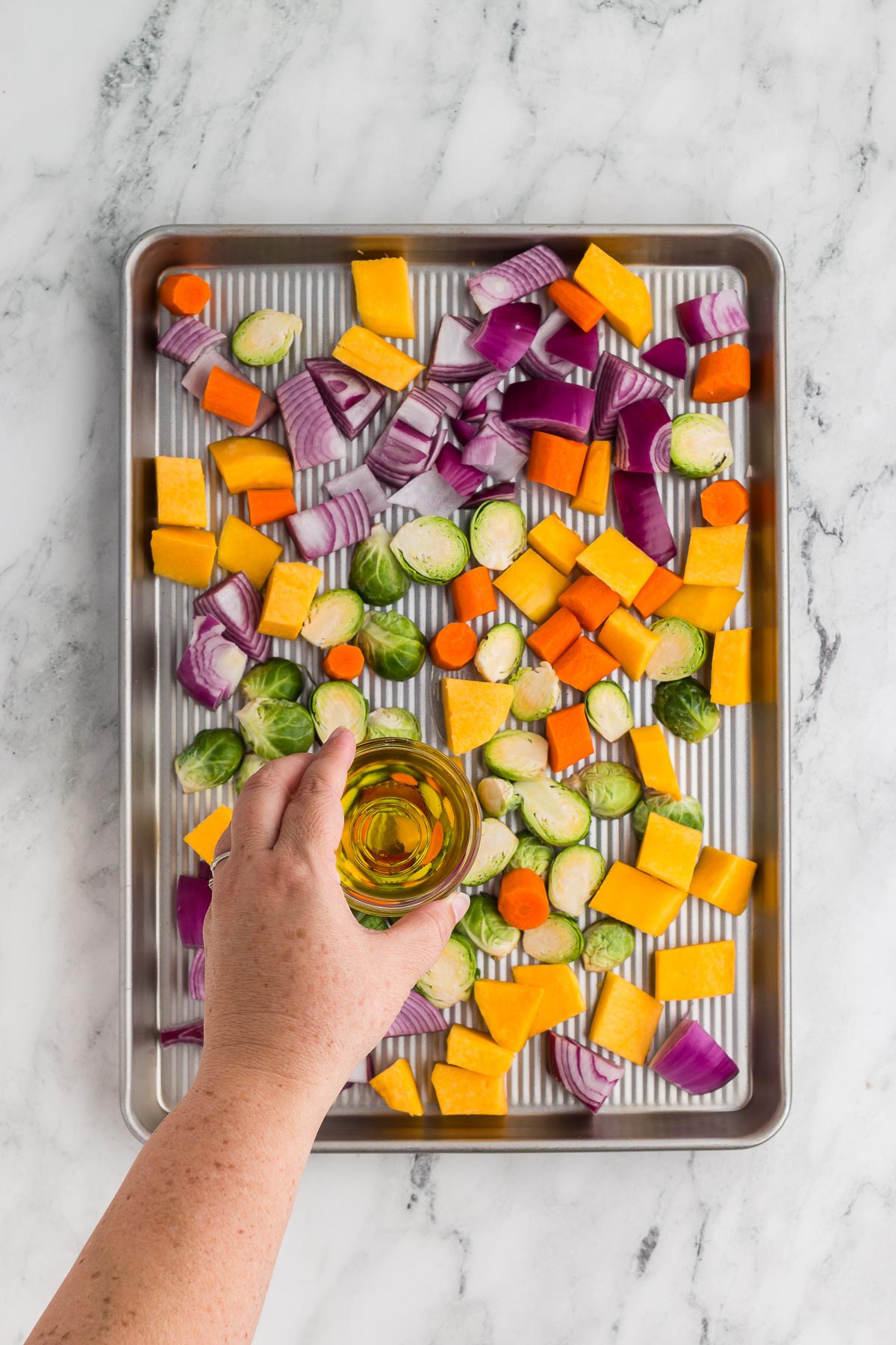 Adding oil to Roasted Fall Vegetables