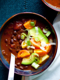 Slow Cooker Black Bean Pumpkin Chili - Black beans, pumpkin, and warming spices simmer together in your Crock Pot to make a vegetarian and vegan pumpkin chili recipe that's perfect for fall.