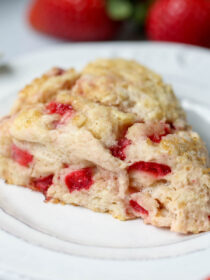 A strawberry scone on a white plate