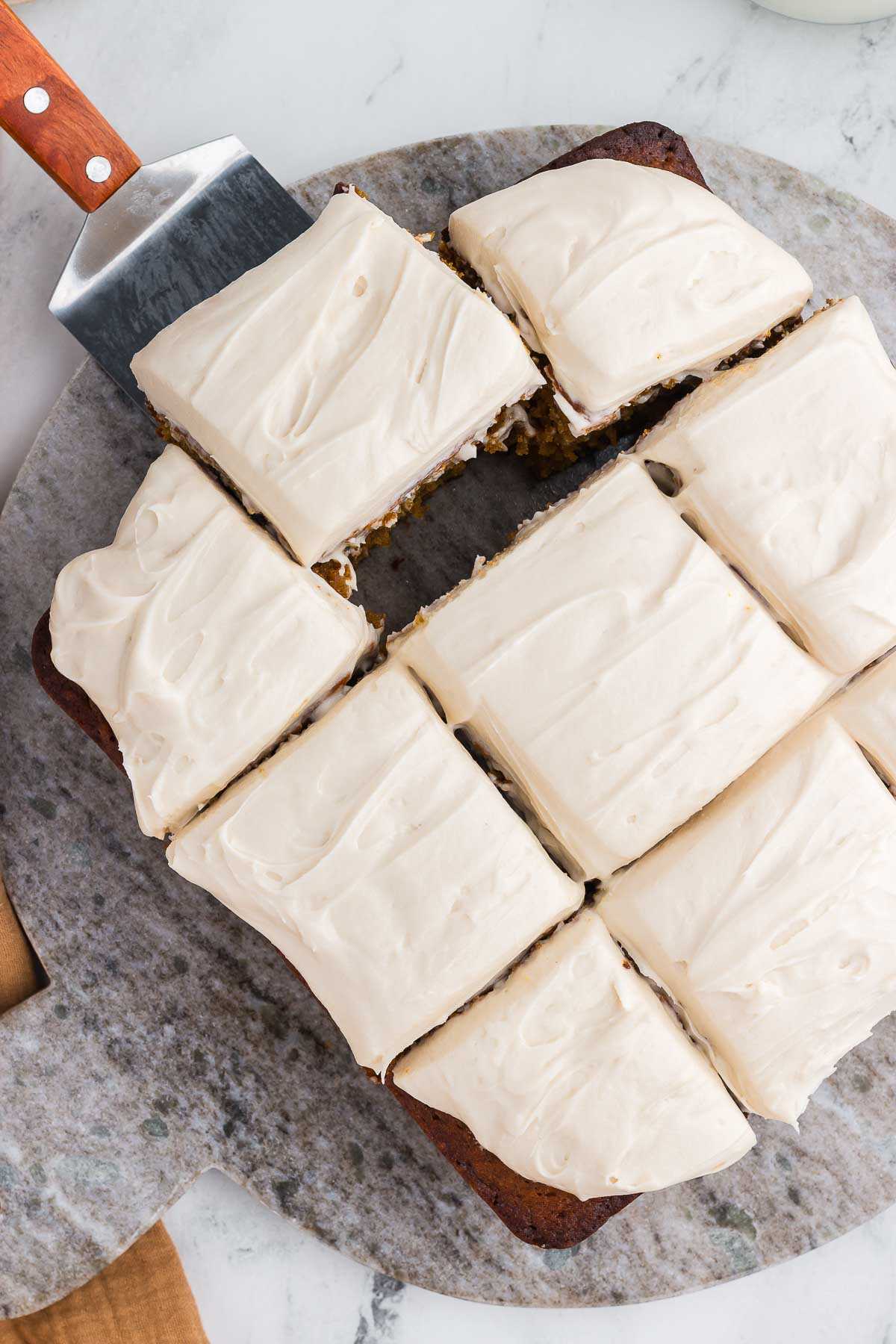 a spatula lifts a square of spiced sweet potato cake