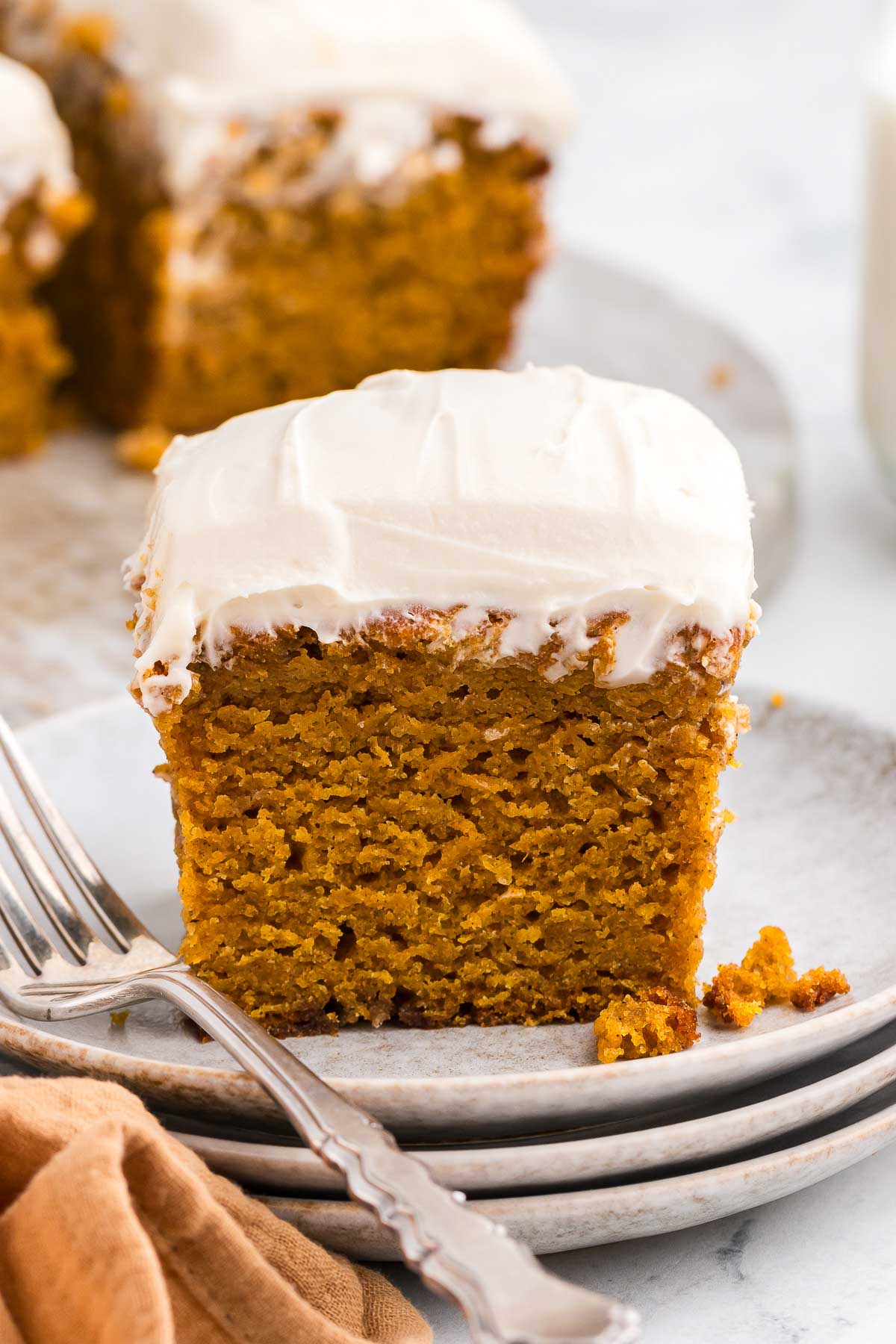 a square of Spiced Sweet Potato Cake on white plates with a silver fork