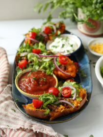 A blue platter with taco sweet potatoes, salsa, and sour cream.