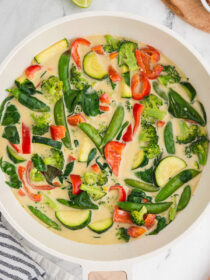 Top view of Thai green curry vegetables with a black and white striped napkin in the background.