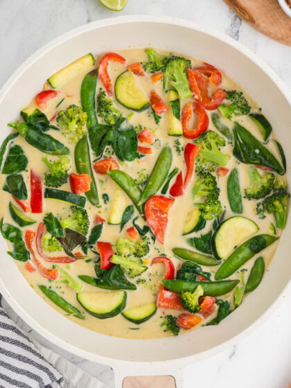 Top view of Thai green curry vegetables with a black and white striped napkin in the background.