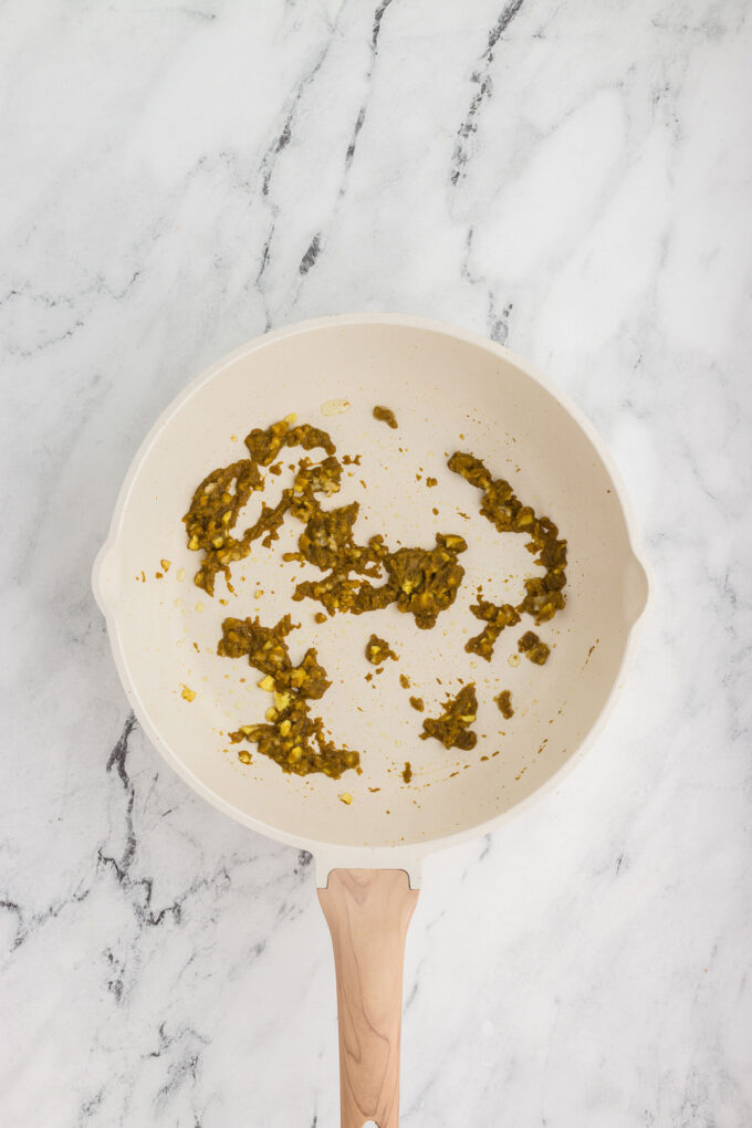 Thai green curry paste being warmed in a skillet.
