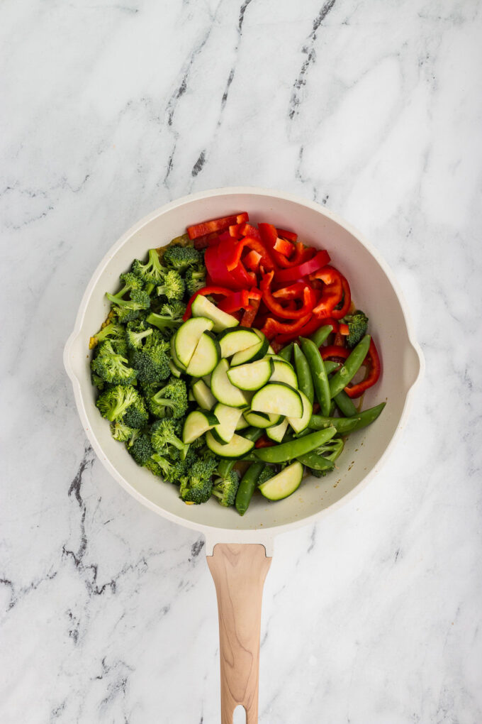 Veggies being added to a saucepan for Thai Green Curry
