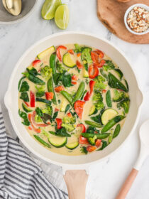 Top view of Thai green curry vegetables with a black and white striped napkin in the background.