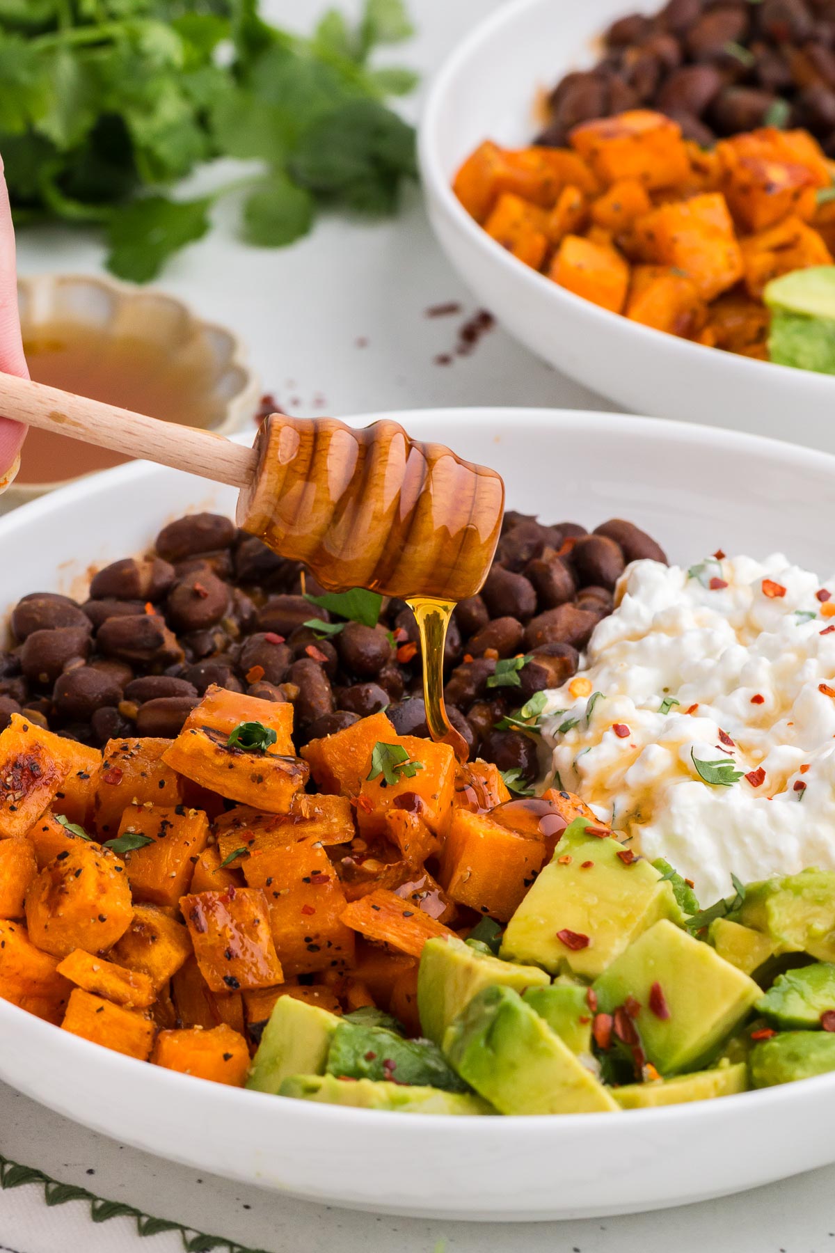 Drizzling hot honey on vegetarian cottage cheese bowls