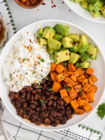 Viral Cottage Cheese Bowl in a white bowl with ingredients in the background